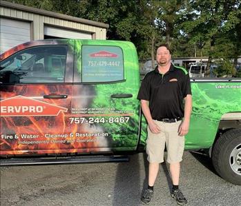 Male employee with brown hair staning infront of SERVPRO truck