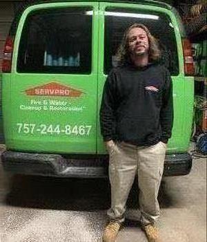 Male employee with light hair standing infront of SERVPRO truck